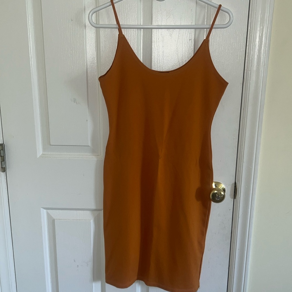 Mustard yellow or dark orange mini dress worn lightly